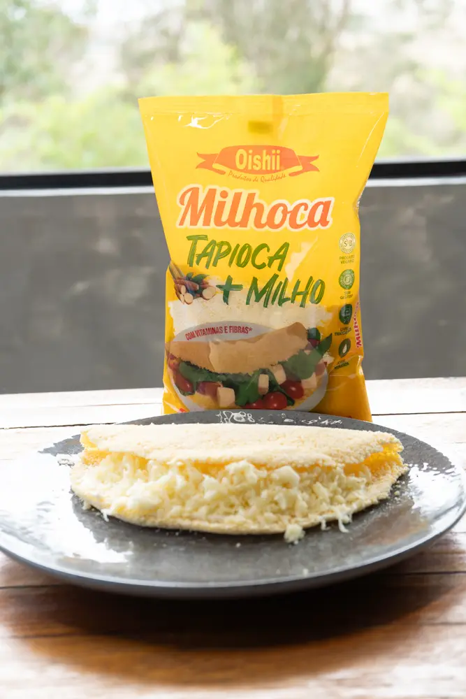 Milhoca com queijo ralado sobre prato cinza
